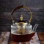 Luxury undulating glass teapot with gold accents and wooden handle